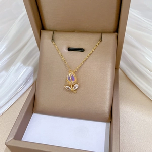 Detailed close-up of a golden tulip pendant with a colorful crystal in a jewelry box