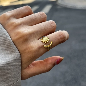 Close-up of 18K gold hammer texture sun and moon open ring on a female finger