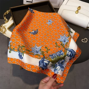 Close-up of orange floral silk scarf with blue patterns on a luxury tray setting