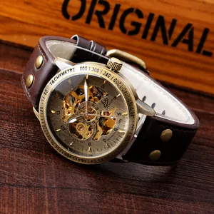 Detail of vintage bronze skeleton watch with brown leather strap and gold rivets
