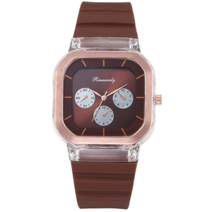 Close-up of brown silicone watch strap with square rose gold frame and textured dial