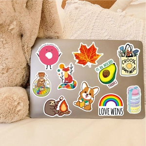Detailed view of colorful VSCO stickers on a laptop featuring donuts and animals