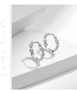 Détail macro des boucles d'oreilles créoles infini en argent S925 avec pavé de zircone