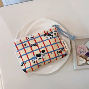 Detail of cartoon dog canvas coin purse with blue zipper and red checkered pattern