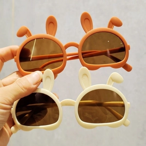Cute bear-ear children sunglasses in orange and beige plastic frames with UV protection
