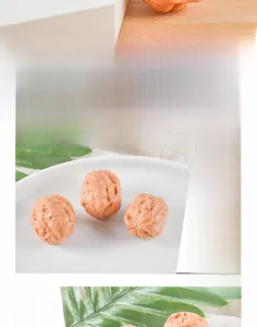 Macro detail of deep brown realistic PVC walnut models on white plate with green leaves