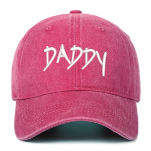 Close-up of white DADDY 3D embroidery on a vintage washed pink baseball cap fabric