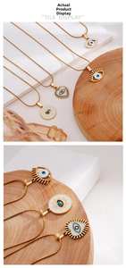 Detailed macro view of golden Evil Eye pendants with blue enamel on sleek snake chains