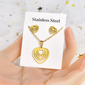 Détail d'un ensemble de bijoux en acier inoxydable doré avec des pièces à motif de cœur