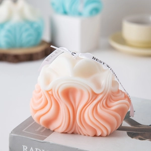 Detailed view of pink gradient wavy scented candle with decorative Best Wishes ribbon