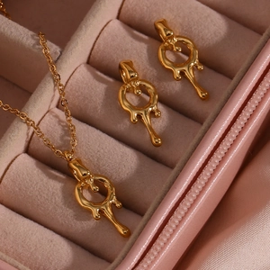 Detailed macro view of 18K gold-plated lava-style necklace and earrings in a pink box