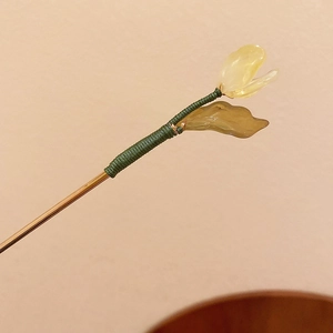 Detail of a Chinese gold hair stick with translucent flower petals and green silk thread