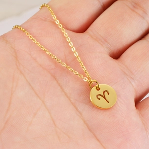 Goldene Edelstahlkette mit Widder-Sternzeichen-Anhänger in der Hand für den Größenvergleich