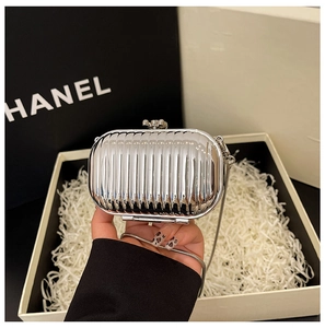 Detail of silver mirror mini clutch bag with ribbed texture and metal snake chain