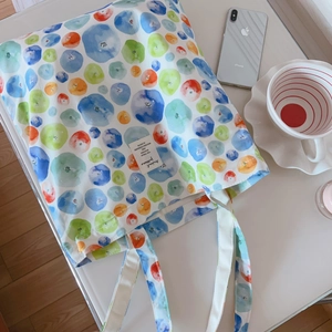 Gros plan du sac cabas en coton imprimé avec motif myrtilles et étiquette blanche