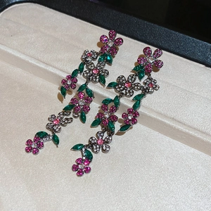 Detail of floral tassel earrings with rose pink and green crystals in gunmetal setting