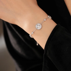 Detailed close-up of 18K gold-plated starburst bracelet with cubic zirconia on model wrist
