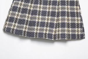 Gros plan du tissu en tweed à carreaux bleu marine et jaune au fini tissé