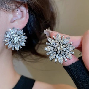 Macro shot of large floral crystal stud earrings featuring marquise and baguette cut gems