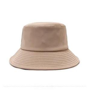 Détail du chapeau bob beige en coton gaufré avec coutures renforcées sur le bord du chapeau