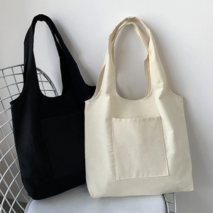 Close-up of black and beige canvas tote bags with front pockets on a metal chair
