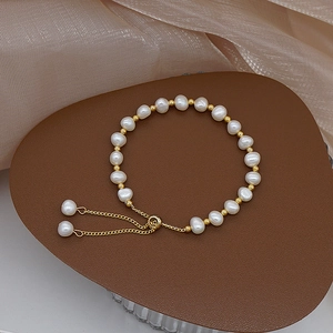 Macro shot of freshwater pearls and gold beads on a luxurious brown jewelry stand