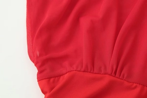 Macro view of red mesh and plain fabric stitching details on elegant women's dress