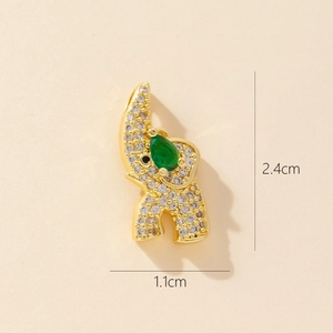 Close-up of gold elephant pendant with green and white stones measuring 2.4cm by 1.1cm