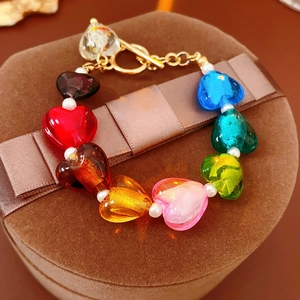 Detail of colorful glass heart beads with golden OT toggle clasp on a satin gift box