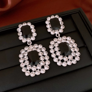 Detailed macro view of vintage silver earrings with black faceted gems and crystal accents