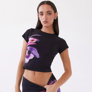 Détail du t-shirt court noir avec imprimé floral violet et rose et col rond élégant