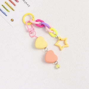 Close-up of yellow and pink resin heart keychain with colorful chain links and stars