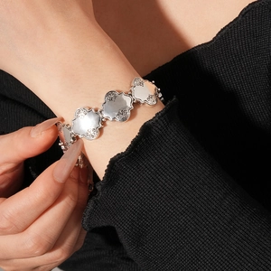 Vue détaillée d'un bracelet argenté vintage avec des motifs floraux en relief