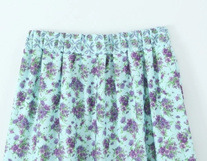 Close-up of elastic waistband on light blue floral skirt with purple flower patterns