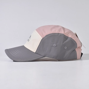 Detail of a 5-panel camper hat with gray brim and metal eyelets for breathability