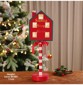 Detailed view of the 32cm Santa Stop Here wooden LED sign with candy cane pole base