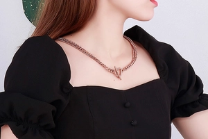 Close-up of a double-layered rose gold chain necklace with a trendy OT buckle toggle