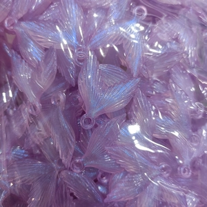 Macro detail of lavender translucent mermaid tail pendants with shimmering glitter finish
