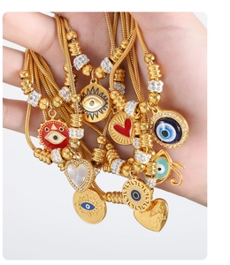 Detail of 18k gold plated stainless steel necklaces with evil eye and heart pendants