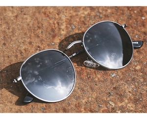 Detailed shot of retro round metal sunglasses featuring a silver frame and dark lenses