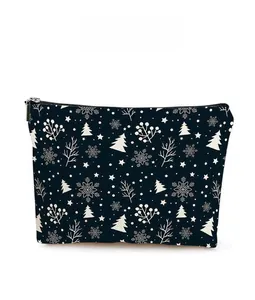 Detail of Christmas themed navy cosmetic bag with white snowflake and tree prints