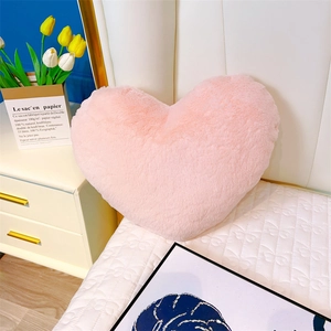 Vue détaillée du coussin cœur en peluche rose douce pour décoration de canapé