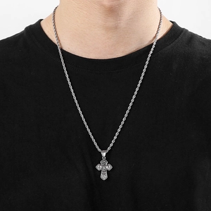Close-up of vintage silver titanium steel cross pendant with turquoise and relief face