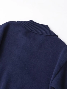 Details des dunkelblauen Strickpullovers mit Rippkragen und Knopf-Textur