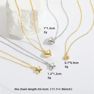 Minimalist gold and silver necklaces with star and heart pendants on white stone background