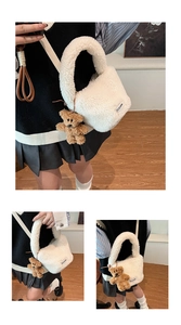 Detail of white faux shearling bucket bag with brown teddy bear charm and logo patch