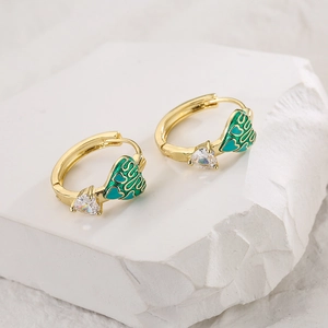 Golden heart earrings with green enamel and triangular zircon on a white stone