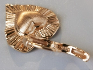 Dettaglio macro del marchio S925 su orecchini a cuore in argento oro rosa
