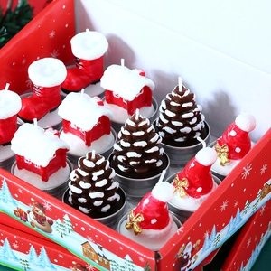 Detailed view of Christmas candle set featuring a red boot, hat, cabin, and pinecone