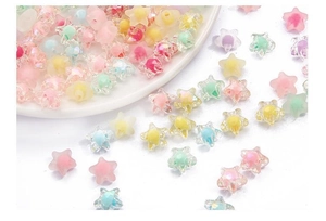 Macro shot of colorful acrylic star beads in pastel pink, yellow, blue, and mint for DIY